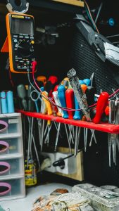 Neatly arranged tools on a workbench, featuring pliers, screwdrivers, and a multimeter.